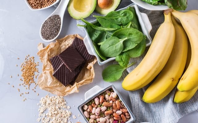 Magnesiumreiche Lebensmittel: Spinat, Bananen, Avocado, dunkle Schokolade, Hülsenfrüchte und Samen