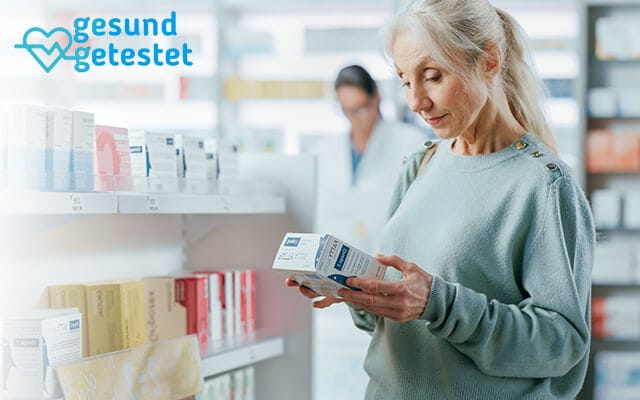 Frau liest in einer Apotheke die Packung eines Nahrungsergänzungsmittels