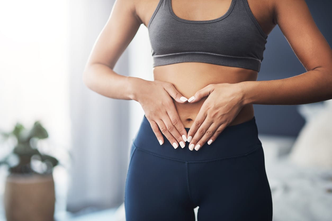 Frau formt mit den Händen ein Herz vor ihrem Bauch