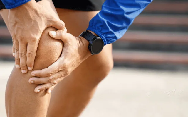 Läufer hält sich das schmerzende Knie