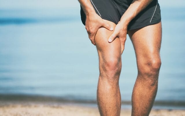 Mann hält sich nach dem Sport den Oberschenkel